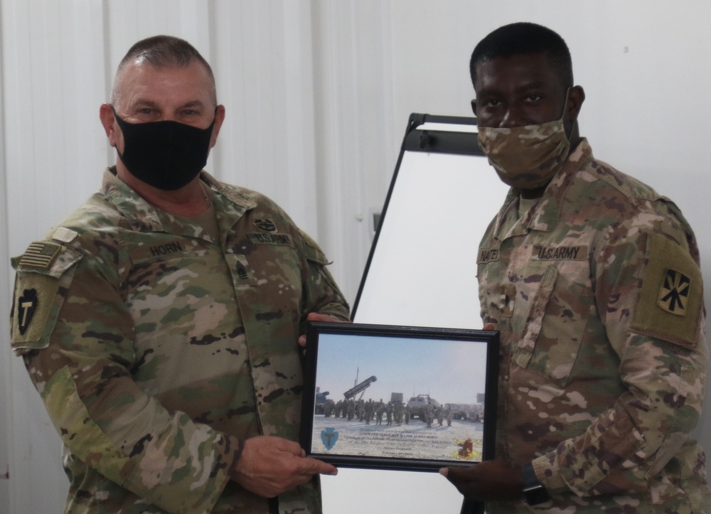 A Soldier from Bravo Battery, 5th Battalion, 52nd Artillery Regiment, present commemorative picture to Task Force Spartan Leadership