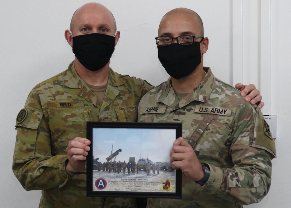 A Soldier from Bravo Battery, 5th Battalion, 52nd Artillery Regiment, present commemorative picture to USARCENT leadership