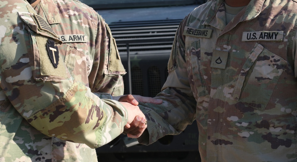 Soldier from 5-52nd ADA receives coin from TFS commander