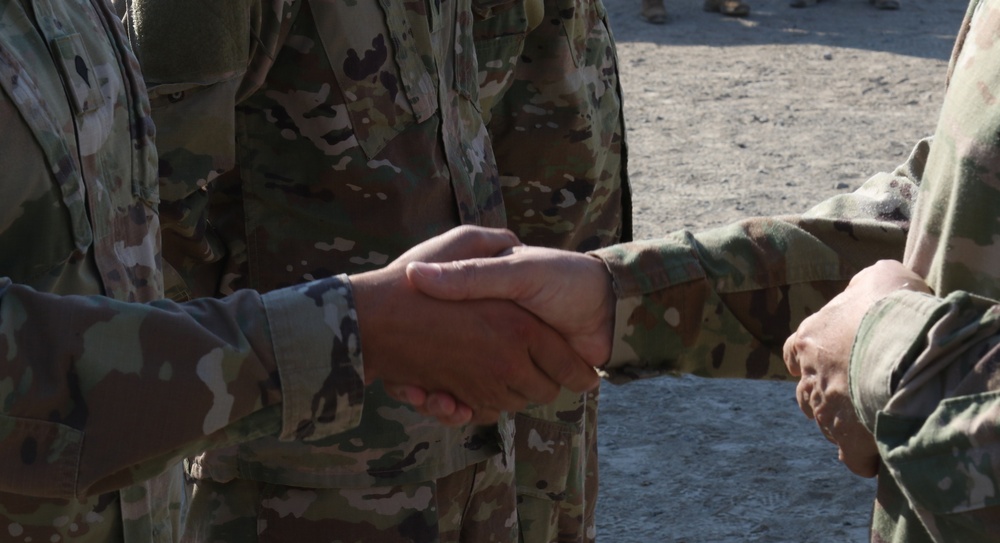 Soldier from 5-52nd ADA receives coin from TFS commander