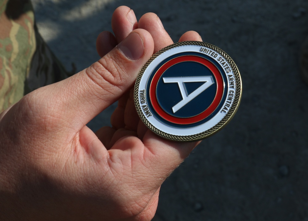 Soldier from 5-52nd ADA receives coin from USARCENT leadership