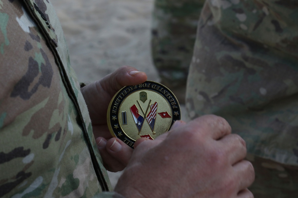 Command Sgt. Maj. Jim Horn, command sergeant major for Task Force Spartan, presents TFS challenge coin for outstanding performance to U.S. Army Soldier form 1st Bn., 6th Inf. Reg.