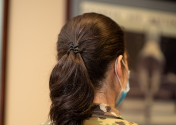 Photo of Tech. Sgt. Cher Schwein displaying the new hairstyle allowed for Air Force women