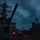 USS BARRY and JMSDF JS TOWADA Night Replenishment at Sea A nighttime or dusk naval scene showing two warships in close proximity, likely conducting an underway replenishment (UNREP) operation at sea. The foreground vessel displays a prominent deck gun turret and superstructure with radar and communications equipment illuminated by orange navigation lights. Personnel are visible on deck amid hoses and rigging connecting the two vessels.
