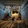 75th EAS moves cargo in East Africa The image shows the interior of a large military cargo aircraft, likely a C-130 or C-17, with personnel seated or crouching on the cargo floor. The cavernous hold features a roller-equipped cargo floor, structural ribbing along the walls and ceiling, and an open rear ramp area visible in the background. Several military personnel in camouflage uniforms appear to be reviewing documents or conducting pre-mission checks.