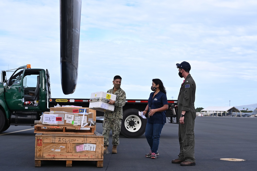 Logisticians deliver high-priority requisitions to a crew providing carrier onboard delivery (COD) support to the Nimitz Carrier Strike Group