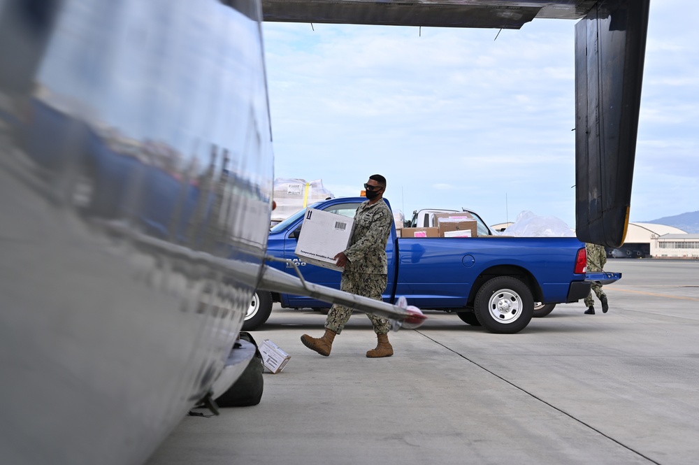 Logisticians deliver high-priority requisitions to a crew providing carrier onboard delivery (COD) support to the Nimitz Carrier Strike Group