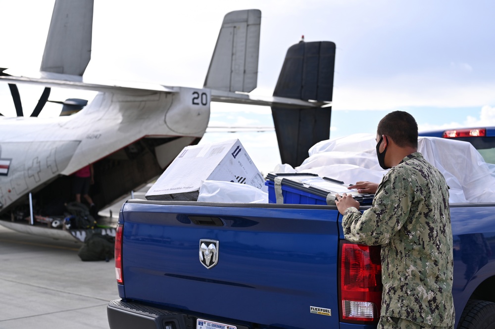 Logisticians deliver high-priority requisitions to a crew providing carrier onboard delivery (COD) support to the Nimitz Carrier Strike Group