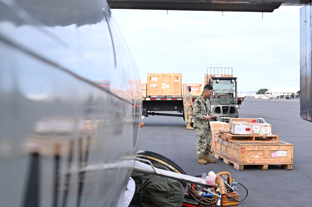 Logisticians deliver high-priority requisitions to a crew providing carrier onboard delivery (COD) support to the Nimitz Carrier Strike Group