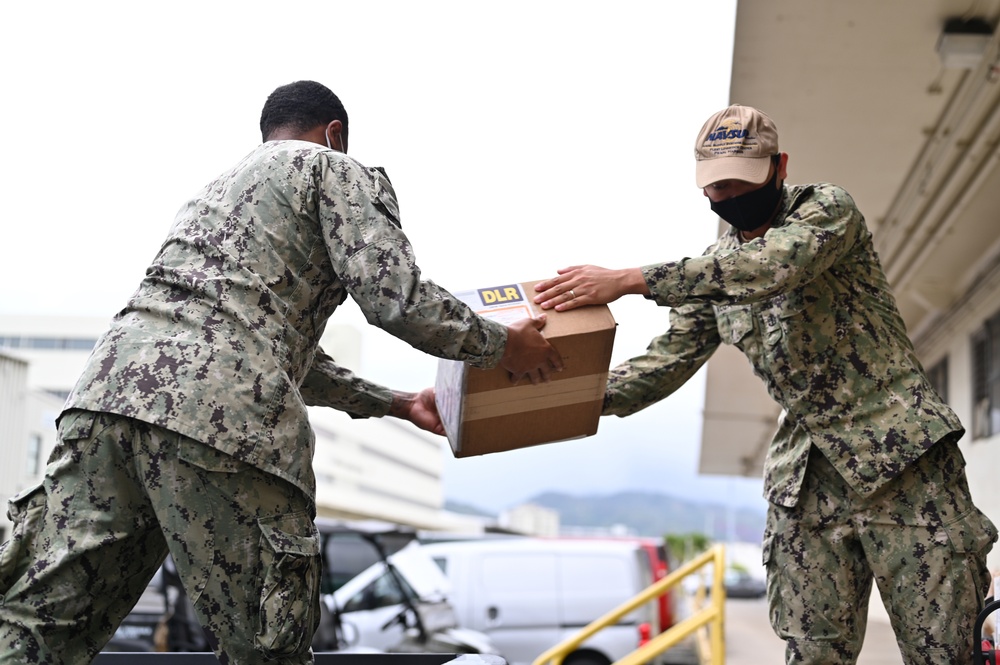 Logisticians deliver high-priority requisitions to a crew providing carrier onboard delivery (COD) support to the Nimitz Carrier Strike Group