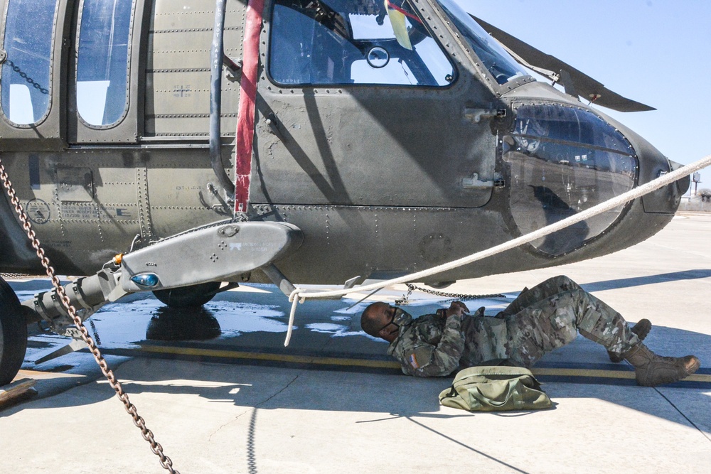 Soldier performs preventative maintenance on UH-60