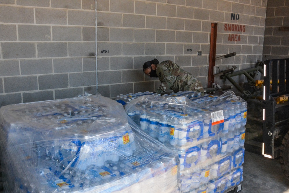 Soldier prepares water for delivery to Texans