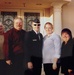 A group of seven people posing together in front of a building with white columns and decorative glass double doors. One individual is wearing a military dress uniform with a garrison cap and sunglasses, suggesting a military occasion such as a graduation or commissioning ceremony. The date stamp in the lower right corner indicates the photo was taken on January 5, 2007.