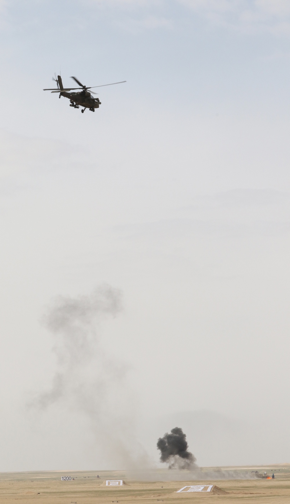 A Kuwait Land Forces Apache helicopter fires rounds down range during exercise Al Tahreer