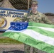 U.S. NAVY SAILOR POSES WITH AN NYPD FLAG IN DJIBOUTI
