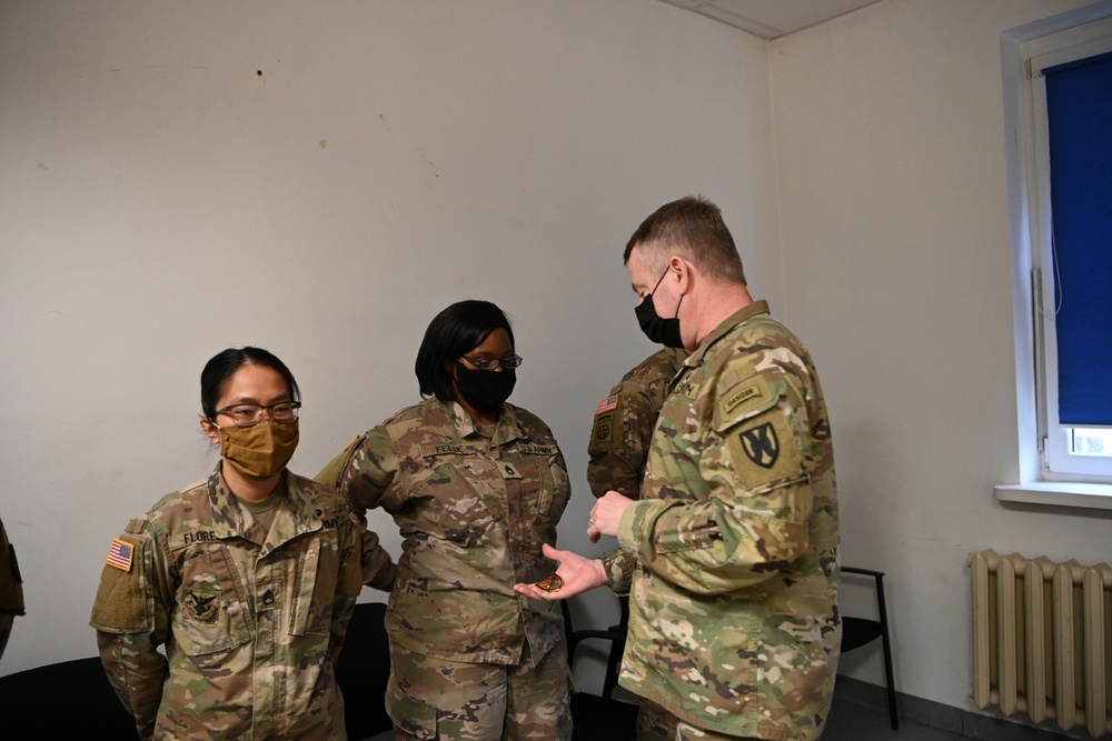 U.S. Army Maj. General Christopher Mohan presents his coin to Alaska Army National Guard Sergeant 1st Class Julena Felix.