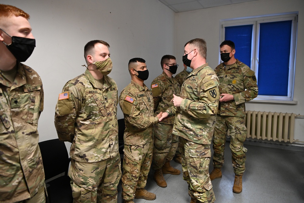 U.S. Army Maj. General Christopher Mohan presents his coin to Alaska Army National Guard Specialist Nathan Aklines.