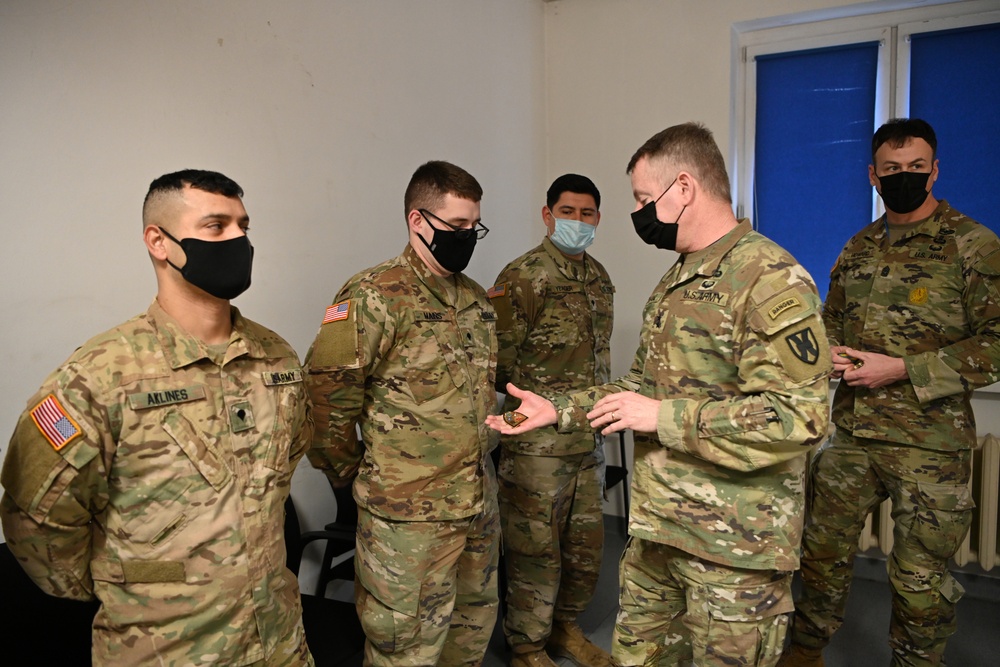 U.S. Army Maj. General Christopher Mohan presents his coin to Alaska Army National Guard Specialist Hunter Mains.