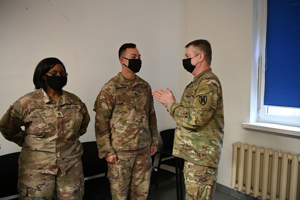 U.S. Army Maj. General Christopher Mohan presents his coin to Alaska Army National Guard Sergeant 1st Class Duane Ostrowski.