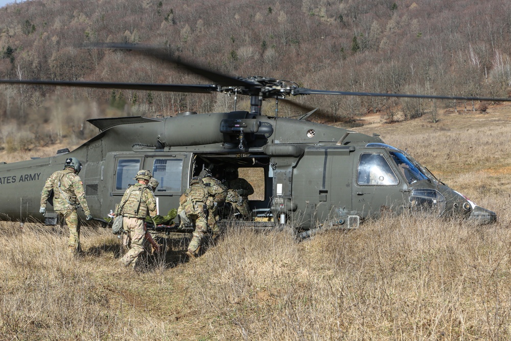 U.S. Soldiers from 115th Brigade Support Battalion, 1st Armored Brigade Combat Team, 1st Calvary Division transports a casualty onto an HH-60M MEDEVAC Blackhawk helicopters.