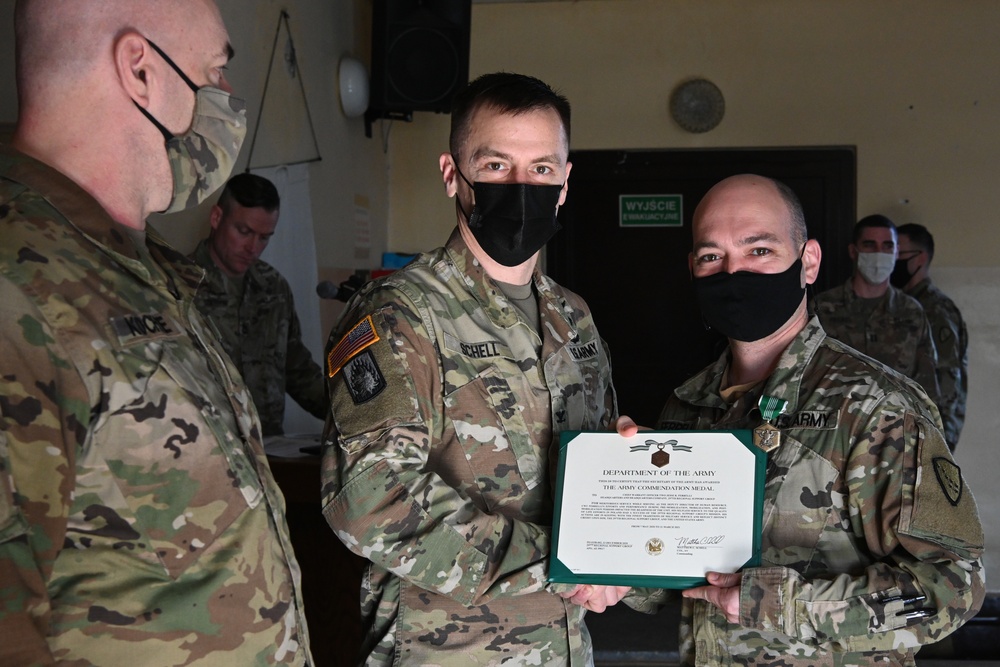 Alaska Army National Guard Chief Warrant Officer 2 Jesse Ferrelli, 297th Regional Support Group, receives an Army Commendation Medal.