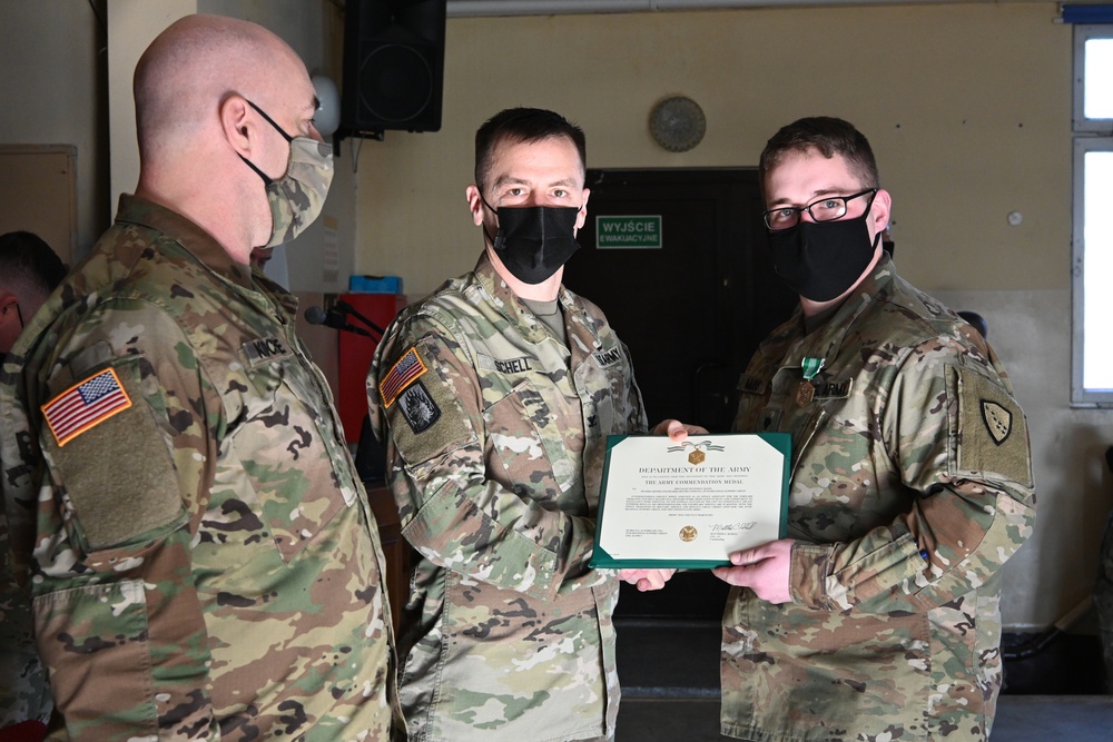 Alaska Army National Guard Specialist Hunter Mains, 297th Regional Support Group, receives an Army Commendation Medal.