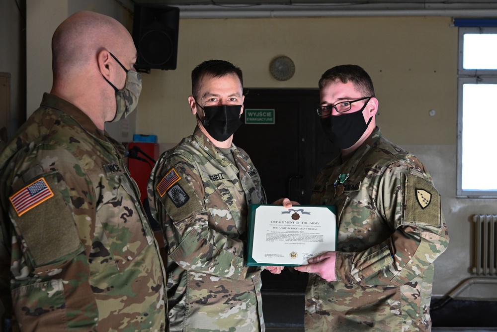 Alaska Army National Guard Specialist Hunter Mains, 297th Regional Support Group, receives an Army Achievement Medal.