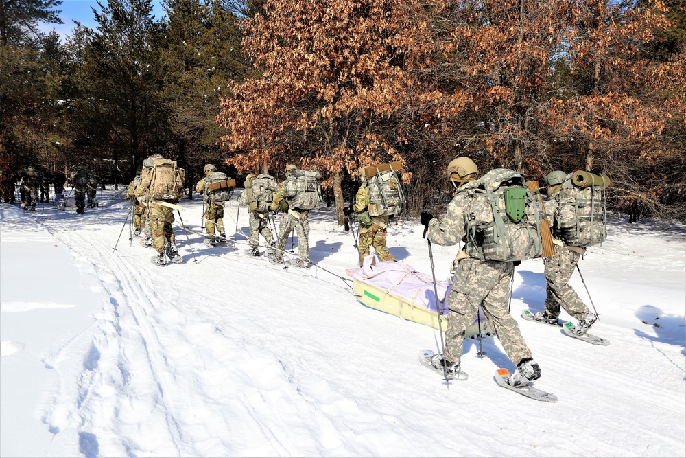 Cold-Weather Operations Course class 21-04 students conduct field training in snowshoes, pulling sleds