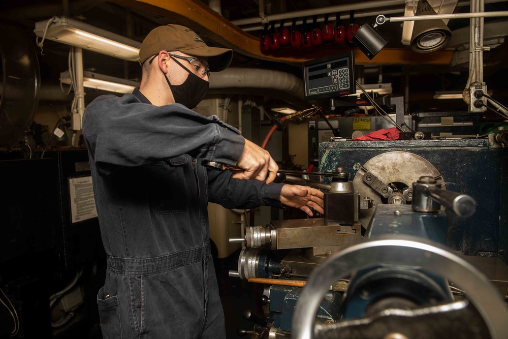 Sailor works on equipment