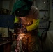 Contractor grinds metal in hangar bay