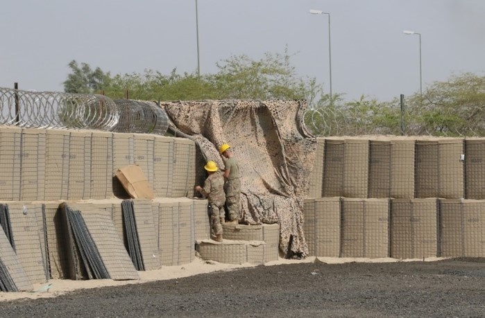 Task Force Iron Castle Engineers and Kuwaiti Land Force Soldiers from the Land Forces Institute collaborate on a forward operating base (FOB) construction project