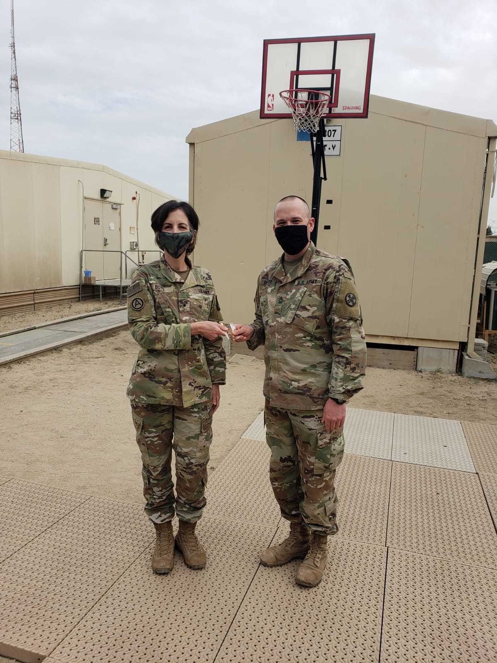 Brigadier General Tina B. Boyd, the G6 of U.S. Army Central awards the Theater Engineer Brigade's Master Sergeant Brad Shaffer with her coin for his hard work in helping establish USARCENT's Signal University.