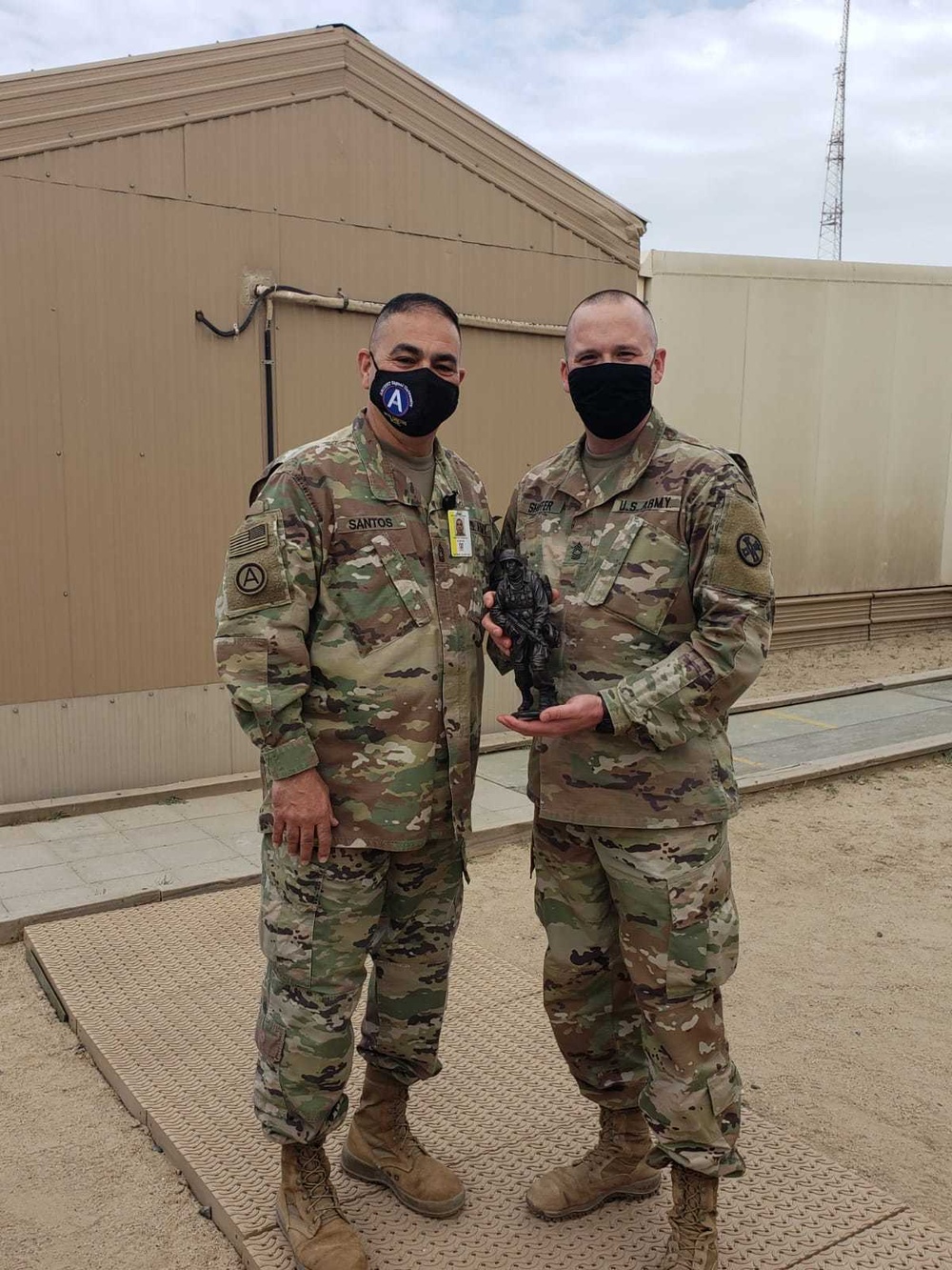 Brigadier General Tina B. Boyd, the G6 of U.S. Army Central awards the Theater Engineer Brigade's Master Sergeant Brad Shaffer with her coin for his hard work in helping establish USARCENT's Signal University.