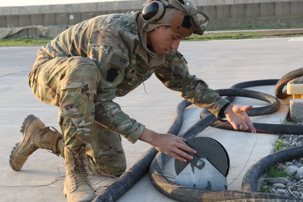 Soldier at a FARP refueling area taking care of fuel needs.