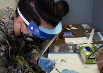 Service members inoculate community members on the opening day of the Jersey City, NJ CVC