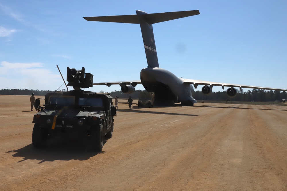 Humvee drives away from Air Force transport plane at Joint Readiness Training Center's Rotation 21-05