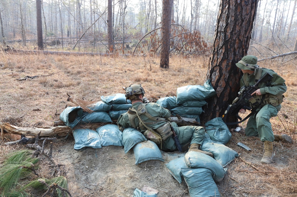 G-man crouched behind tree and sand bags await the 1st Brigade Combat Team, 82nd Air Borne Division