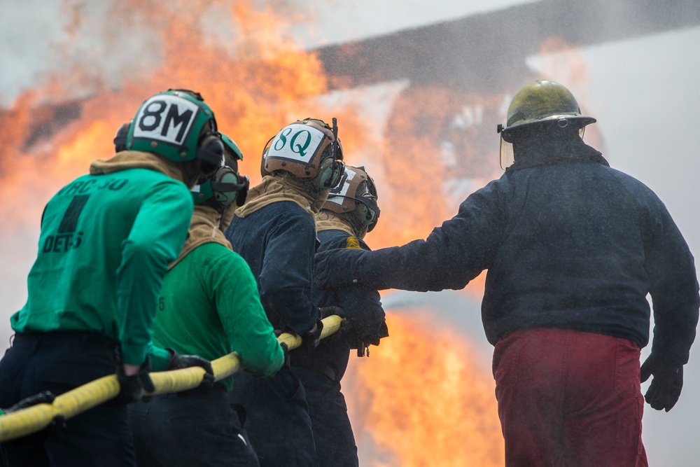 U.S. Navy Sailors with Fleet Logistics Support Squadron (VRC) 30, DET-5, Carrier Air Wing Five (CVW-5) conduct an airfield firefighting exercise