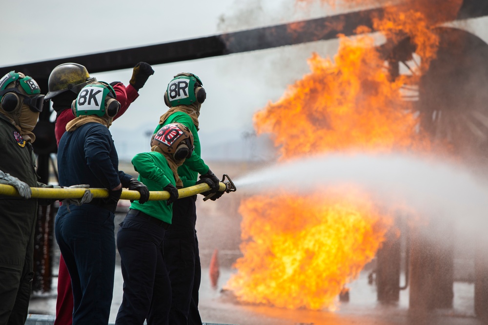 U.S. Navy Sailors with Fleet Logistics Support Squadron (VRC) 30, DET-5, Carrier Air Wing Five (CVW-5) conduct an airfield firefighting exercise