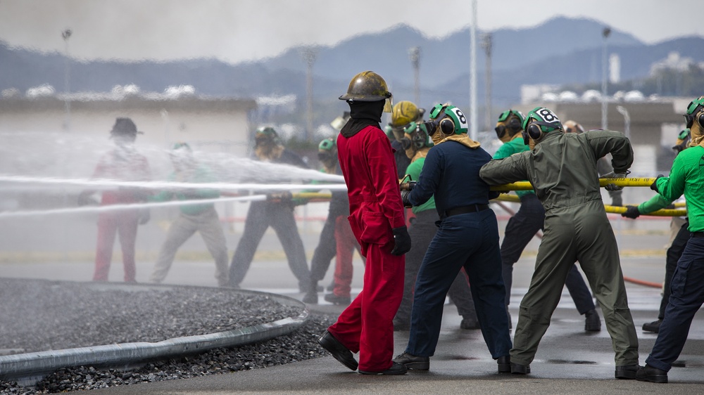 U.S. Navy Sailors with Fleet Logistics Support Squadron (VRC) 30, DET-5, Carrier Air Wing Five (CVW-5) conduct an airfield firefighting exercise