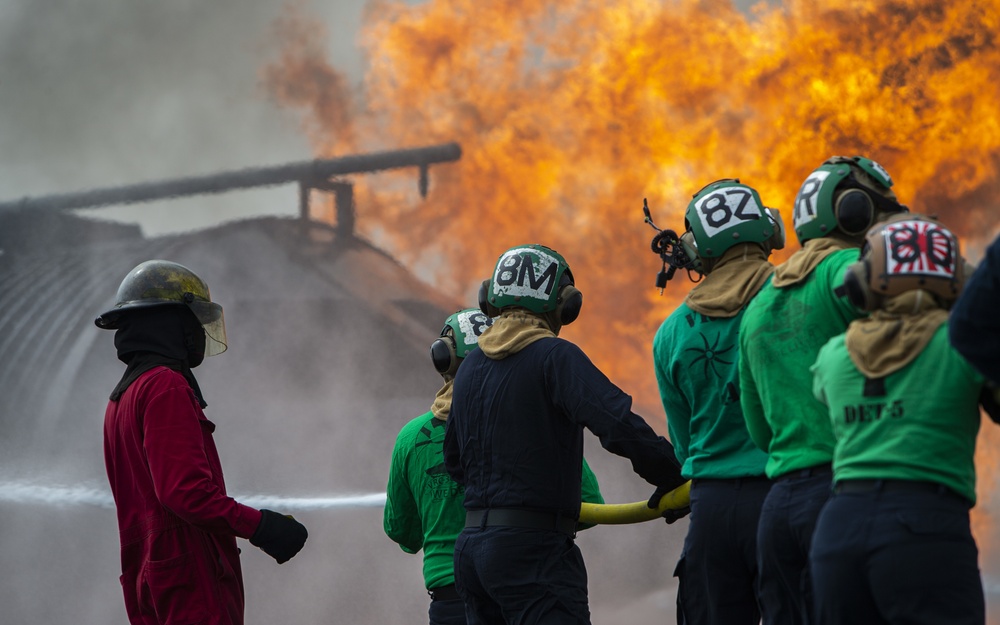 U.S. Navy Sailors with Fleet Logistics Support Squadron (VRC) 30, DET-5, Carrier Air Wing Five (CVW-5) conduct an airfield firefighting exercise