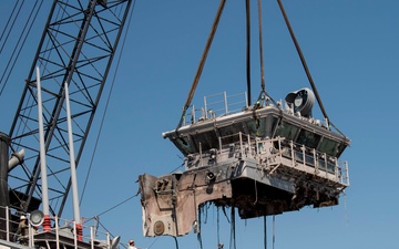Salvage contractors remove pieces of USS Bonhomme Richard superstructure to ready the ship for towing