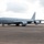 420th ABS supports Baltic Trident Exercise A U.S. Air Force KC-135 Stratotanker aerial refueling aircraft is parked on a tarmac apron, likely at a military airfield. The aircraft is painted in standard gray livery with 'U.S. AIR FORCE' markings on the fuselage and a unit insignia near the nose. At least one ground crew member in a high-visibility vest is visible near the aircraft.