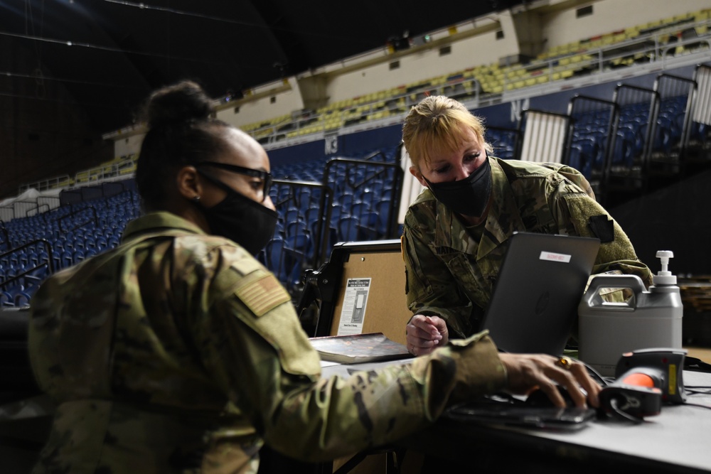 U.S. Army Lt. Col. Dee Watkins views a computer with Senior Airman Joielle Cobb-Sanders, as part of keeping track of units that have out processed from the Capitol Response mission