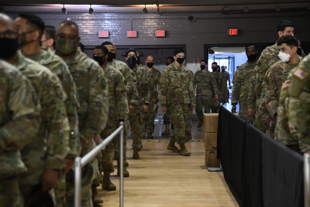 U.S. Soldiers from New Jersey Army National Guard wait in line to outprocess from the Capitol Response mission to return to their home state at the District of Columbia Armory in Washington, D.C., March 14, 2021