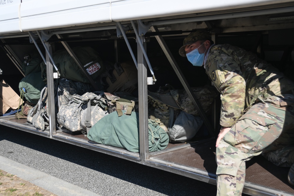 A U.S. Soldier from New Jersey Army National Guard waits to load luggage on a bus after outprocessing from the Capitol Response mission to return to their home state at the District of Columbia Armory in Washington, D.C., March 14, 2021