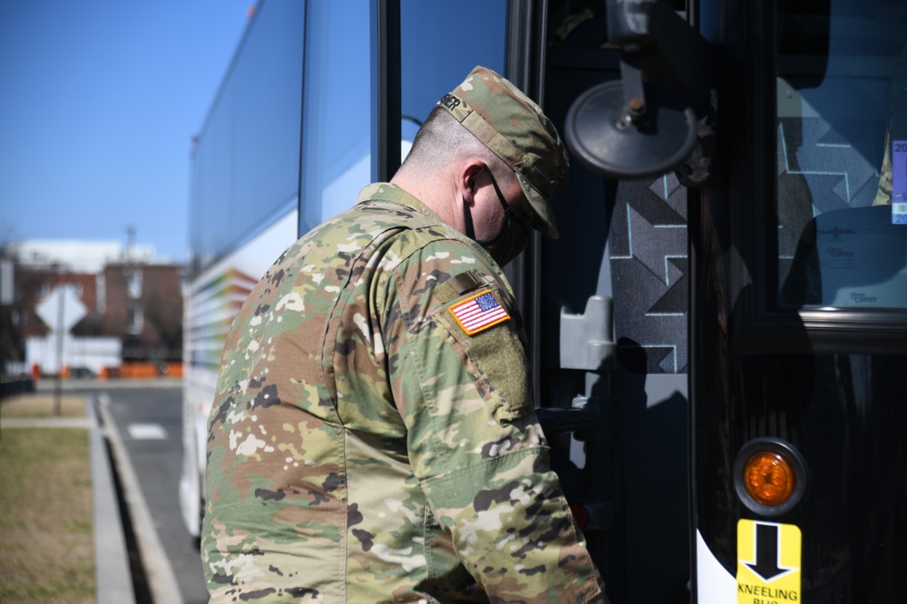 A U.S. Soldier from New Jersey Army National Guard boards a bus after outprocessing from the Capitol Response mission to return to their home state, at the District of Columbia Armory in Washington, D.C., March 14, 2021