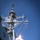 A naval warship is launching a missile from its vertical launch system (VLS), with a large plume of white and orange exhaust smoke visible at the base of the missile. The vessel appears to be a U.S. Navy guided-missile destroyer, identifiable by the hull number '15' visible on the superstructure. The image was taken from a low angle against a clear blue sky, capturing the missile in the early phase of its ascent.