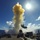A missile is being launched from the deck of a naval warship at sea under a bright, sunny sky. The launch produces a large plume of yellow-white exhaust smoke billowing upward as the missile ascends. The image appears to be an official military photograph documenting a weapons test or combat operation.