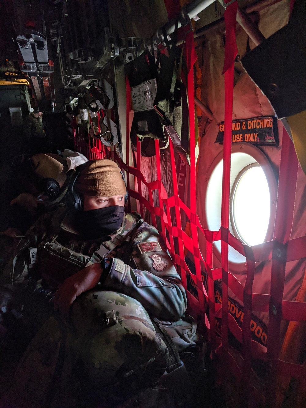 Colorado Air National Guardsman looks out over Greenland terrain from a C-130 Hercules during participation in Arctic Air Defense Exercise AMALGAM DART